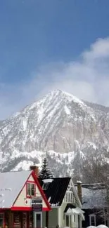 Snowy mountain village with colorful houses and majestic peak.