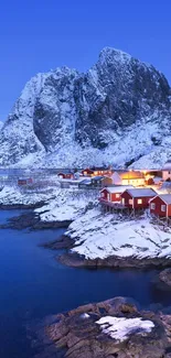 Snow-covered village with mountain backdrop.