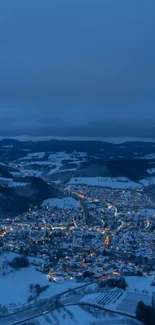 Snowy village at night with glowing lights and blue sky.