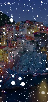 Colorful village at night with snowfall on a cliffside, perfect for mobile wallpaper.