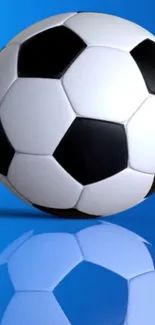 Black and white soccer ball on a vibrant blue background with reflection.