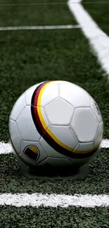 Soccer ball on green field with white lines.