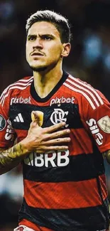 Focused soccer player in red jersey during a match.