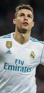 Soccer player in white jersey celebrating on the field.