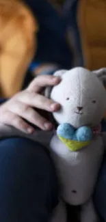 Child holds plush bunny on lap, wearing cozy outfit.