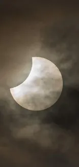 Solar eclipse with clouds in dark sky.