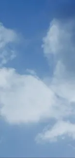 A serene blue sky with fluffy white clouds.