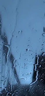 Raindrops on glass surface with a soothing blue background.