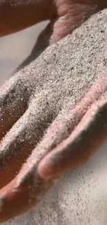 Close-up of sand cascading through fingers in a calming, natural scene.