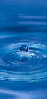 A single water drop creates ripples in a soothing blue background.