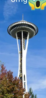 Space Needle tower against a bright blue sky with fall trees.