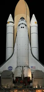 Space shuttle ready for launch at night.