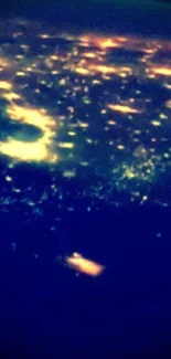 City lights viewed from space, glowing in dark.