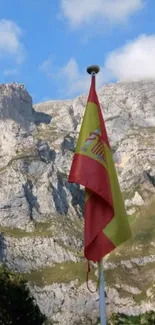 Spanish flag with mountainous backdrop and blue sky.