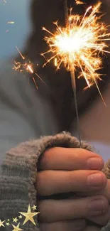 Cozy sweater hand holding a festive sparkler.