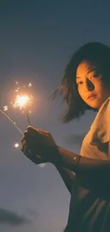 Nighttime silhouette holding sparkler under a starry sky on a mobile wallpaper.