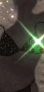 Sparkling bikini silhouette with star effects on gray background.