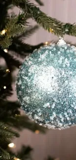 Blue sparkling ornament on a Christmas tree.