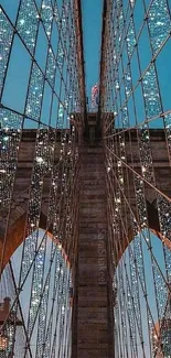 Illuminated bridge at night with sparkling lights and blue sky.