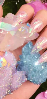 Hand holding iridescent crystals among pink hydrangea flowers.