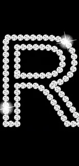 Sparkling diamond initial R on black wallpaper.