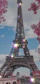 Eiffel Tower with sparkling lights, surrounded by pink blossoms.