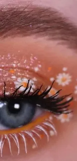 Close-up of eye with glitter and floral makeup art.