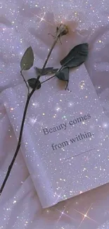 A rose on a sparkling book with the quote 'Beauty comes from within.'