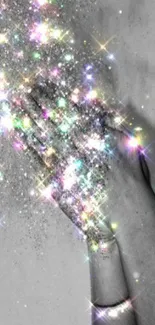 Hand releasing colorful sparkling stardust in grayscale background.