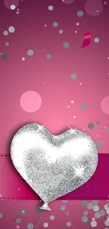 A silver heart balloon on a vibrant pink background, adding sparkle and festivity.