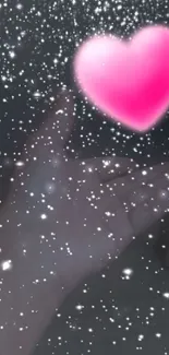 Floating pink heart above hand with sparkling stars.