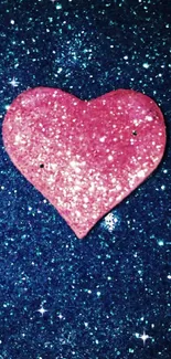 Sparkling pink heart on blue glitter background wallpaper.