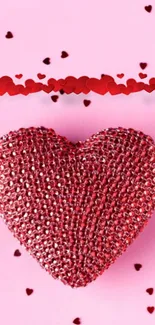 Red glitter heart on pink background with scattered small hearts.