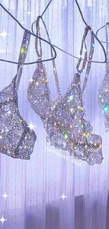 Sparkling crystal-studded lingerie on hangers with a pastel curtain.