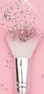 A pink brush with glitter on a pink background.