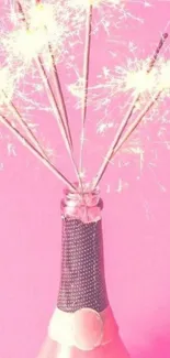 Pink champagne bottle with sparklers on a festive pink background.