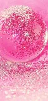 Sparkling pink globe with glitter accents on vibrant background.