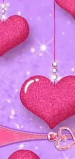 Mobile wallpaper with pink hearts and purple background.