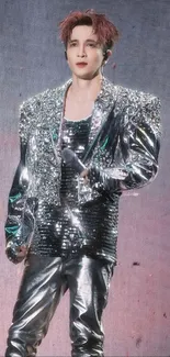 Performer in sparkling silver outfit on stage.