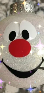 Sparkling snowman ornament with a red nose on a glittery background.