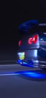 Sportscar with blue lights speeding at night on a dark road.