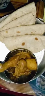 Plate of spicy curry and flatbread in vibrant Indian cuisine display.