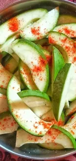 Sliced mango sprinkled with chili powder on red fabric.