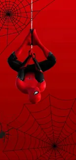 Upside-down superhero against red web backdrop.