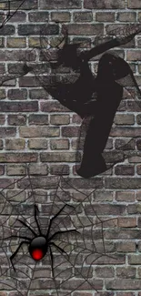 Spider-themed artwork on a brick wall background featuring a web and spider design.