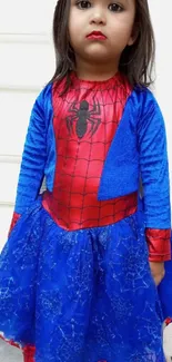 Child in Spiderman outfit with blue dress.