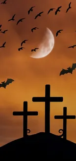 Silhouetted crosses and bats against an orange night sky and moon.