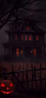 A haunted house with glowing windows and a carved pumpkin for Halloween night.