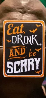 Halloween wallpaper with 'Eat, Drink, and Be Scary' in orange and white.