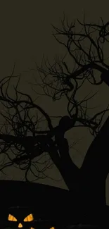 Spooky Halloween night wallpaper with pumpkins and a dark, eerie tree.